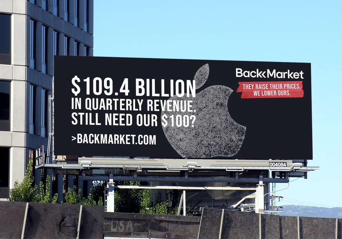 Billboard: “$109.4 billion in quarterly revenue. Still need our $100?” over a bitten-apple shape, with the Back Market logo and “They raise their prices. We lower ours.”